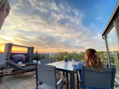 a woman sitting at a table on a patio at The Love suite 1 Athens Riviera in Athens