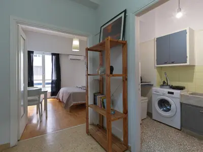 a small room with a kitchen and a washing machine at Homy Pagrati flat 100 Mbps, 12' to Panathenaic Stadium, 5' to Metro in Athens