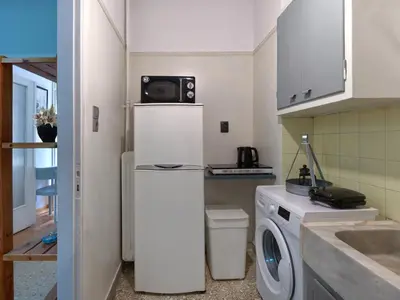 a kitchen with a washing machine and a microwave at Homy Pagrati flat 100 Mbps, 12' to Panathenaic Stadium, 5' to Metro in Athens