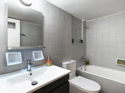 a bathroom with a sink and a toilet and a tub at Homy Pagrati flat 100 Mbps, 12' to Panathenaic Stadium, 5' to Metro in Athens
