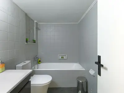a white bathroom with a tub and a toilet at Homy Pagrati flat 100 Mbps, 12' to Panathenaic Stadium, 5' to Metro in Athens