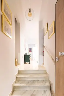 a hallway with stairs in a home with white walls at Athens Escape in Athens