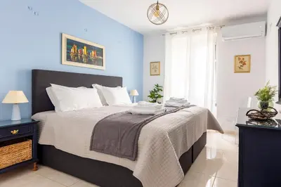 a bedroom with a large bed with a blue wall at Athens Escape in Athens