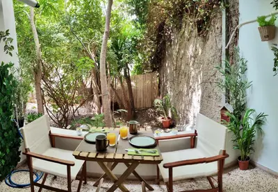 a table and chairs on a patio with trees at Athens Escape in Athens