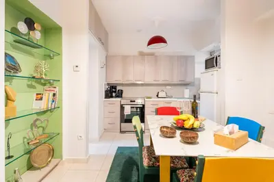 a kitchen with a table with a bowl of fruit on it at Athens Escape in Athens