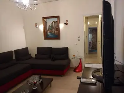 a living room with a couch and a tv at Cosy penthouse next to metro in Athens