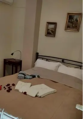 a bed with towels and flowers on it at Cosy penthouse next to metro in Athens