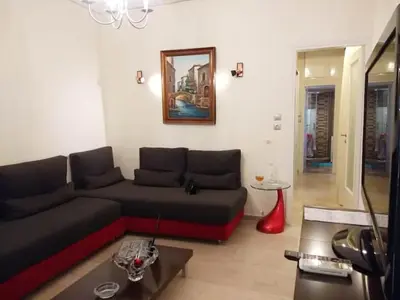 a living room with a couch and a table at Cosy penthouse next to metro in Athens