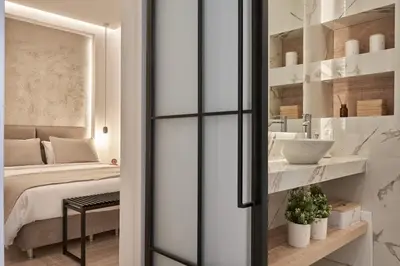 a bedroom with a bed and a bathroom with a sink at Charitos Heights Boutique Apt II, Kolonaki in Athens