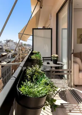 a balcony with potted plants and a table at Charitos Heights Boutique Apt II, Kolonaki in Athens