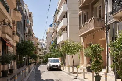 a white van driving down a street with buildings at Charitos Heights Boutique Apt II, Kolonaki in Athens