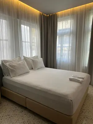 a bedroom with a bed with white pillows and windows at Belle Athenes - Luxury Rooms at Monastiraki Railway Station in Athens
