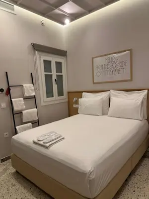a bedroom with a large bed with white sheets and pillows at Belle Athenes - Luxury Rooms at Monastiraki Railway Station in Athens