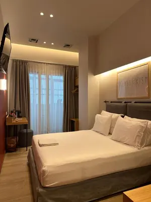 a bedroom with a large white bed in front of a window at Belle Athenes - Luxury Rooms at Monastiraki Railway Station in Athens