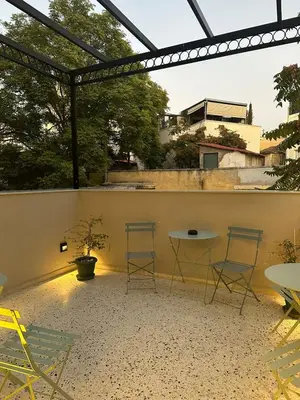 a patio with two chairs and a table on a wall at Belle Athenes - Luxury Rooms at Monastiraki Railway Station in Athens