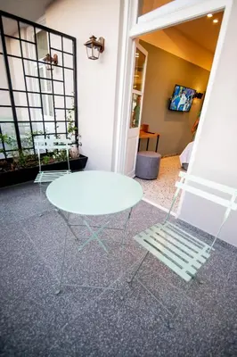 a white table and a chair in a room at Belle Athenes - Luxury Rooms at Monastiraki Railway Station in Athens