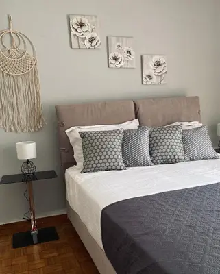 a bed with gray and white pillows in a bedroom at Athens Sunnyside condo in Athens