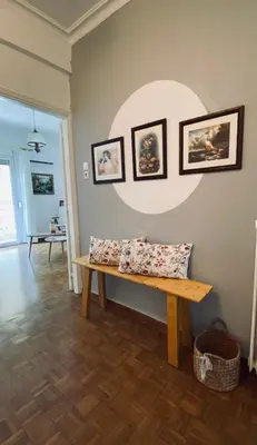 a living room with a bench and pictures on the wall at Athens Sunnyside condo in Athens