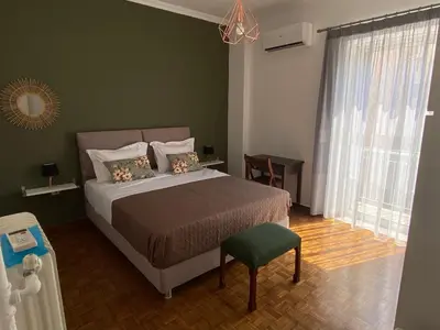 a bedroom with a bed and a green wall at Athens Sunnyside condo in Athens
