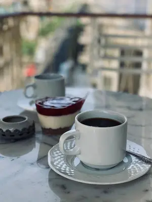 a cup of coffee and a piece of cake on a table at Athens Sunnyside condo in Athens