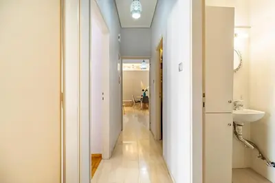 a hallway leading to a bathroom with a sink at Urban grey in Athens