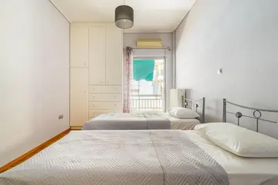 a bedroom with two beds and a window at Urban grey in Athens