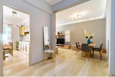 a dining room and living room with a table and chairs at Urban grey in Athens