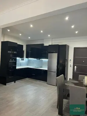 a kitchen with black and white cabinets and a table at Thiseio Residence 58 in Athens