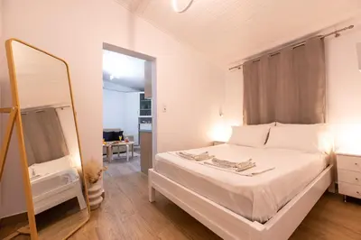 a bedroom with a white bed and a mirror at Eden - A Night near Athens Int Arpt in Spáta