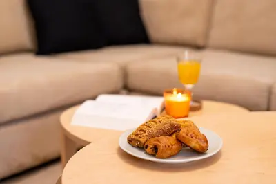 a plate of pastries on a table with a couch at Eden - A Night near Athens Int Arpt in Spáta
