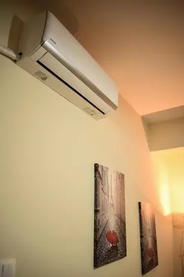 a ceiling light with two pictures on the wall at Όμορφο διαμέρισμα στην περιοχή της Ηλιούπολης in Athens