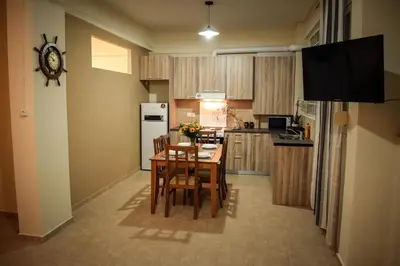 a kitchen with a table and chairs and a refrigerator at Όμορφο διαμέρισμα στην περιοχή της Ηλιούπολης in Athens