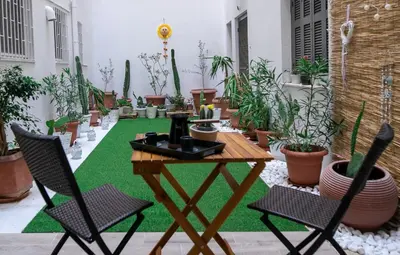 a patio with a table and chairs and potted plants at Hesperides Garden in Athens