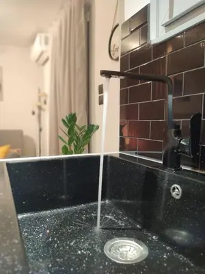 a kitchen sink with water running from a faucet at Hesperides Garden in Athens