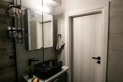 a bathroom with a black sink and a mirror at Hesperides Garden in Athens