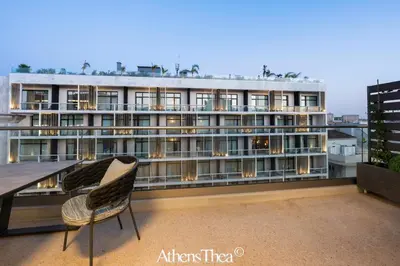 a building with a table and chairs on a balcony at AthensThea Alpha Luxury Penthouse Apt in Omonia in Athens