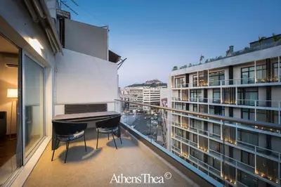 a balcony with a table and chairs on a building at AthensThea Beta Luxury Penthouse Apt in Omonia in Athens