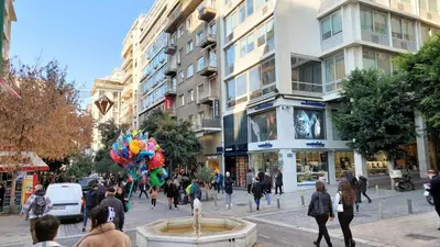 a group of people walking down a busy city street at Elegant apartment in Syntagma square in Athens