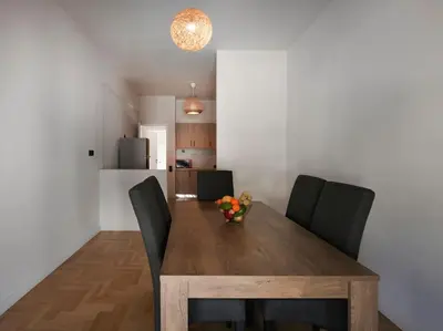 a dining room table with chairs and a vase of flowers on it at Lycabettus view apartment in Athens