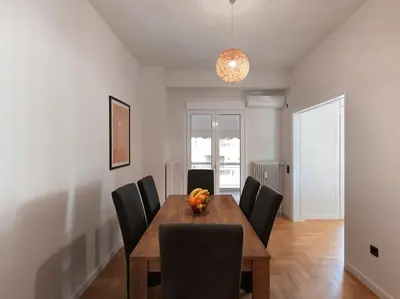 a dining room with a wooden table and black chairs at Lycabettus view apartment in Athens