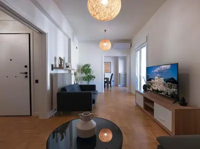 a living room with a couch and a tv and a table at Lycabettus view apartment in Athens