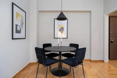 a dining room with a black table and chairs at The Beehive Apartments in Athens