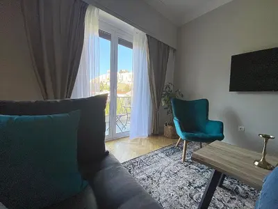 a living room with a couch and a table and a window at Check Point - Acropolis View B in Athens
