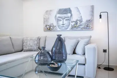 a living room with a couch and two vases on a glass table at Acropolis Cozy Apartments in Athens