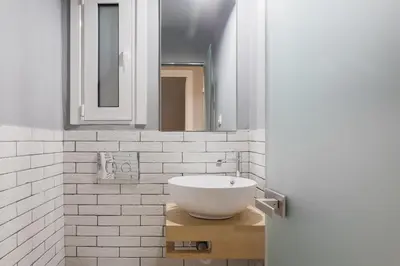 a white bathroom with a sink and a mirror at Stunning 2BR Apartment in Lycabettus by UPSTREET in Athens