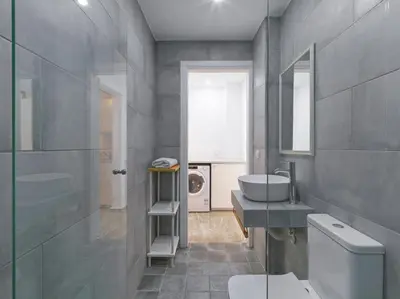 a bathroom with a sink and a toilet and a mirror at Elegant, affordable apartment with a fireplace in Athens