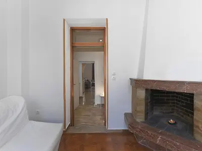 a living room with a fireplace and a bed at Elegant, affordable apartment with a fireplace in Athens