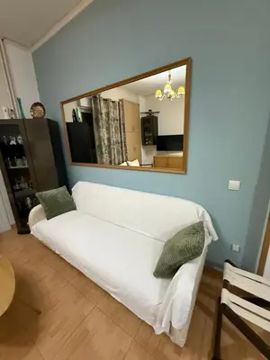 a white couch in a living room with a mirror at Athens Room in Athens