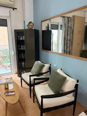 a living room with two chairs and a mirror at Athens Room in Athens