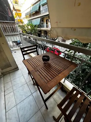 a wooden table and chairs on a balcony at Athens Room in Athens